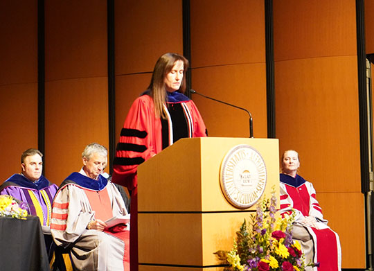 woman in red robe at podium