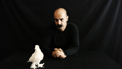 figure of a man on black background white dove in foredground