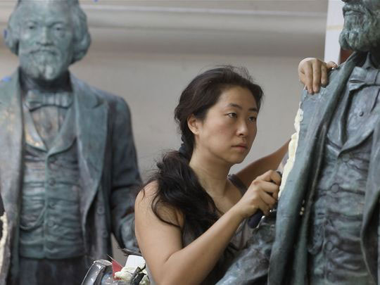 woman working on statues