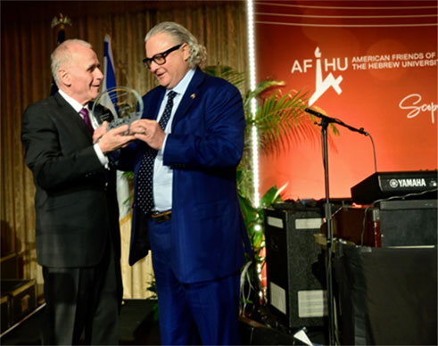 photo of one man presenting an award to another