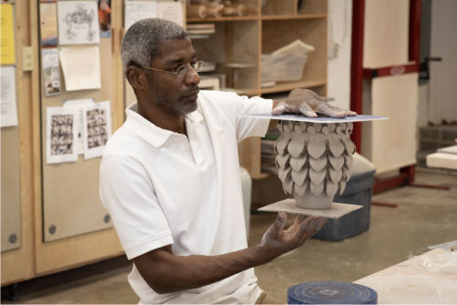 man holding ceramic pottery