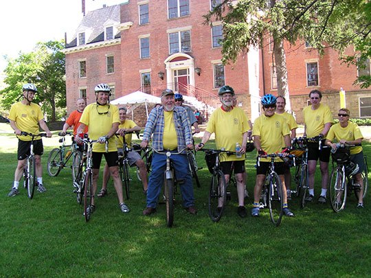 group of bicyclists in front of a brick building