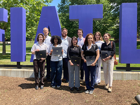 group of people standing in front of a sign