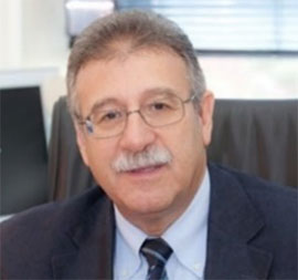 headshot of man in suit and tie, wearing glasses
