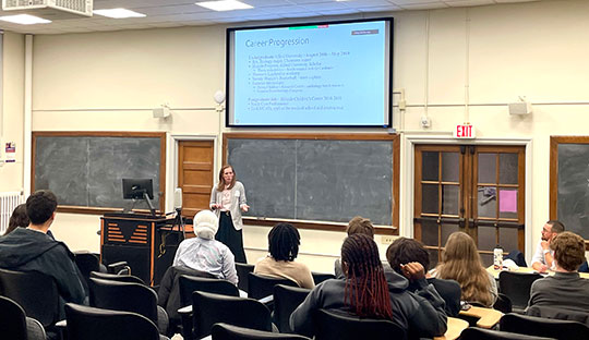 woman standing in front of a projector, speaking