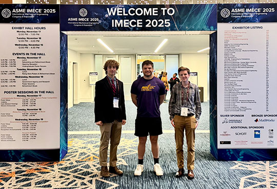 three young men standing in front of posters