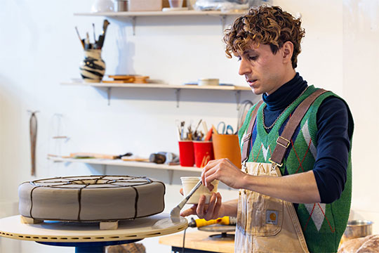 man working on a piece of pottery