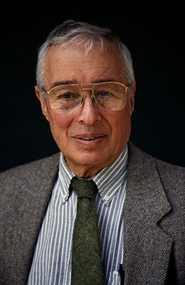 headshot of man with coat and tie, glasses