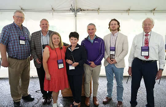 group of two women and five men, standing in a row