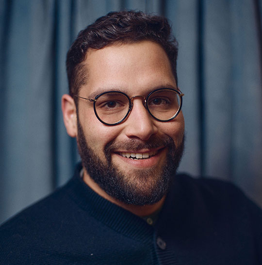 headshot of smiling man with glasses