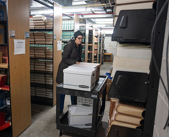 woman with hat moving a couple boxes
