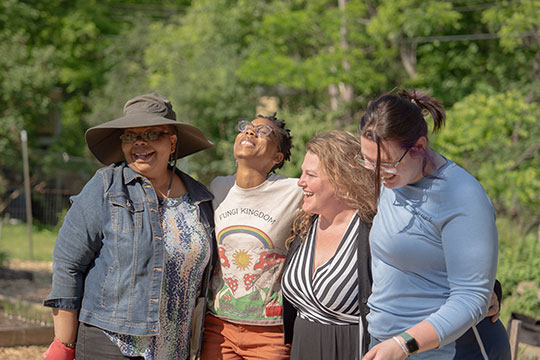 photo of four people, side by side, laughing