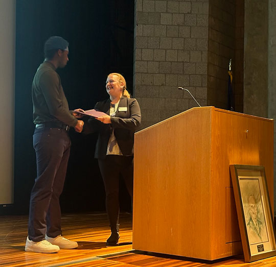 man getting a certificate from woman standing at podium