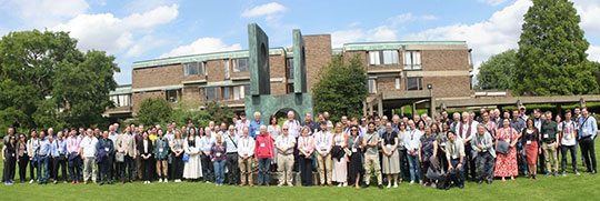 group of many people standing in front of a statue and building