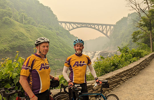 two men standing next to bicycles