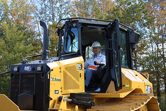 man with hard hat operating a bulldozer