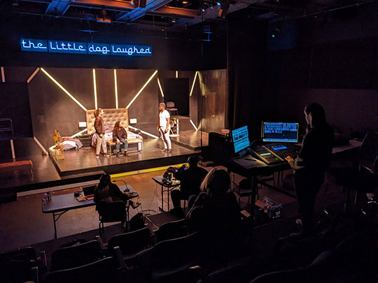 people at computers monitoring a stage production