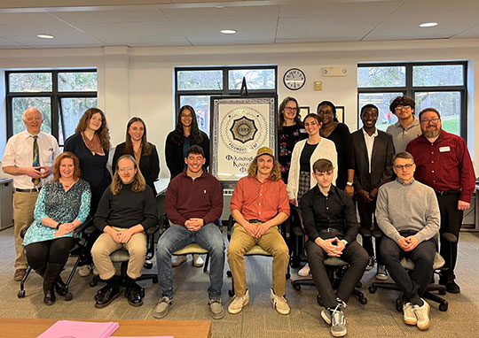 photo of several people sitting or standing, front and back rows