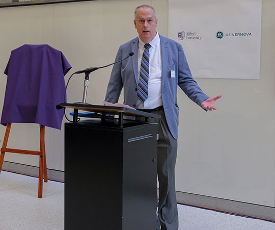 man talking at ribbon-cutting ceremony for new power grid training lab