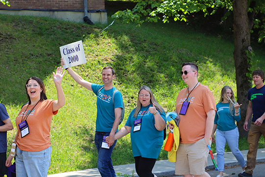 people walking in a procession, holding signs