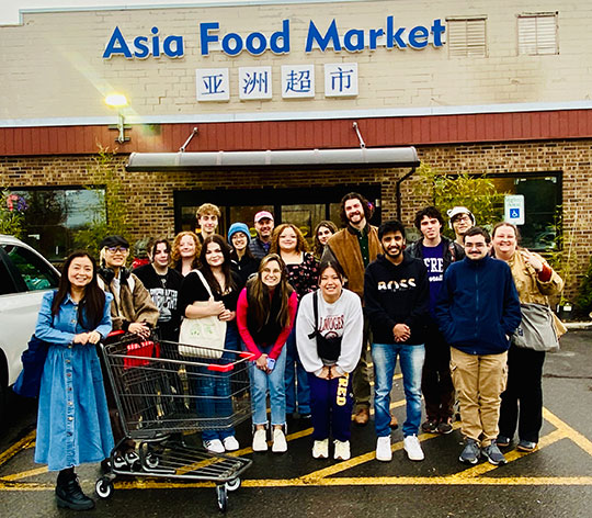 group of people standing in front of an Asian supermarket