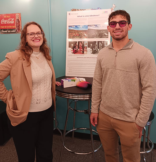 woman with glasses standing at a table next to man with glasses