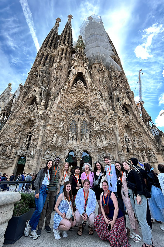 group of students and faculty standing in front of church under construction
