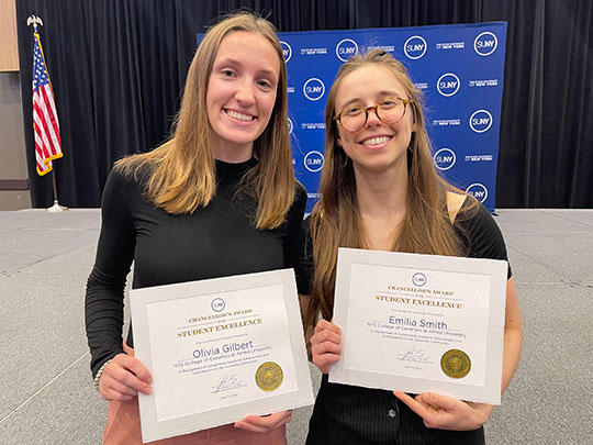 two women holding certificates