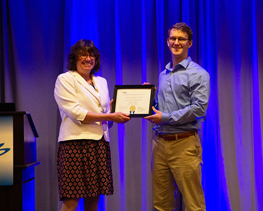 man receiving plaque from a woman