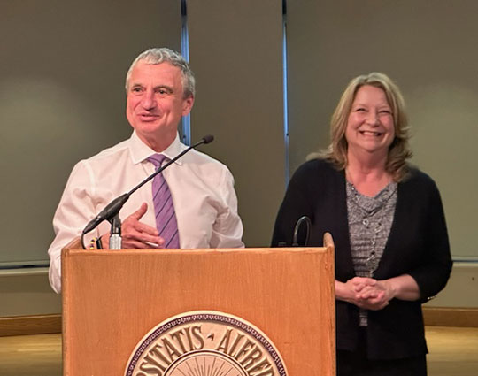 woman and man standing by podium