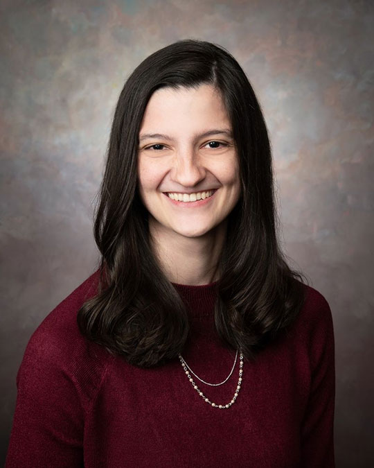 headshot of woman with long dark hair smiling