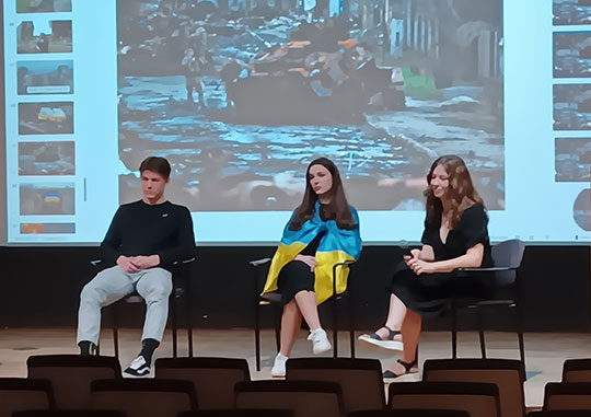 three students on a stage