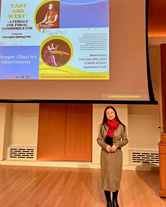 woman with long hair on stage giving a lecture