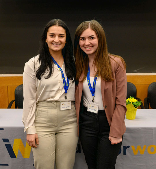 two young women standing and smiling