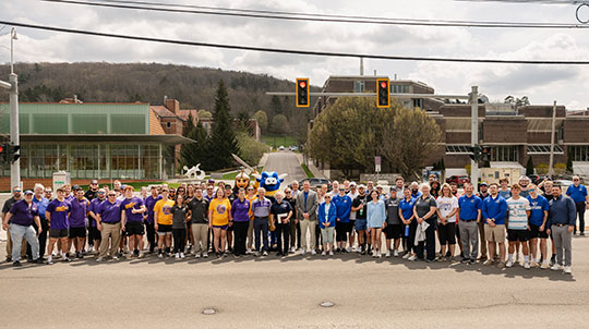 large group of people standing under a traffic light