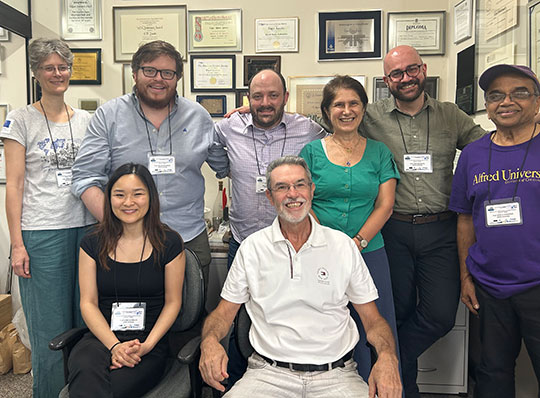 group of people smiling at camera, in two rows