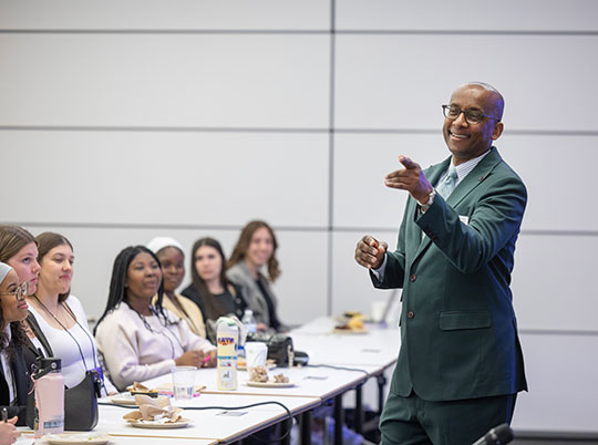 man standing and talking to a group of students
