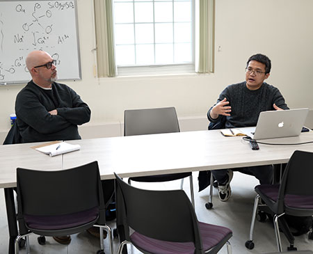 two men at a table talking