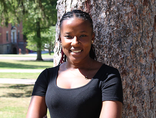 Headshot of woman standing next to a tree