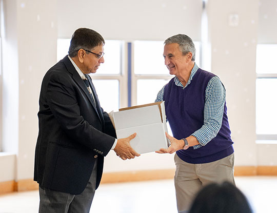 man presenting another man with a box