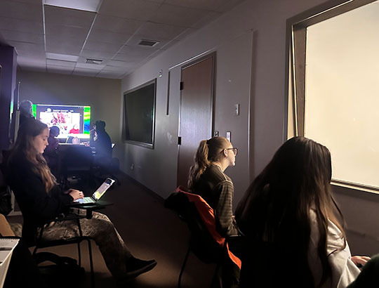 people sitting and looking through a one-way mirror