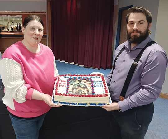 two people holding a cake