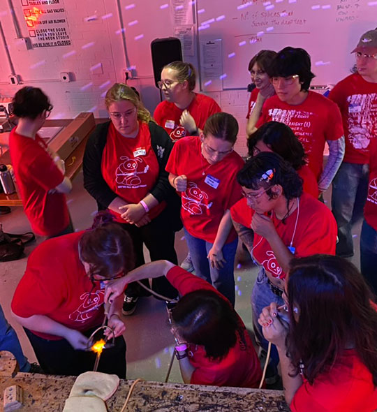 large group of people standing and working with glass
