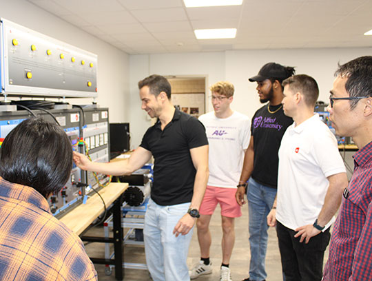 several people gathered around a man giving an equipment demonstration