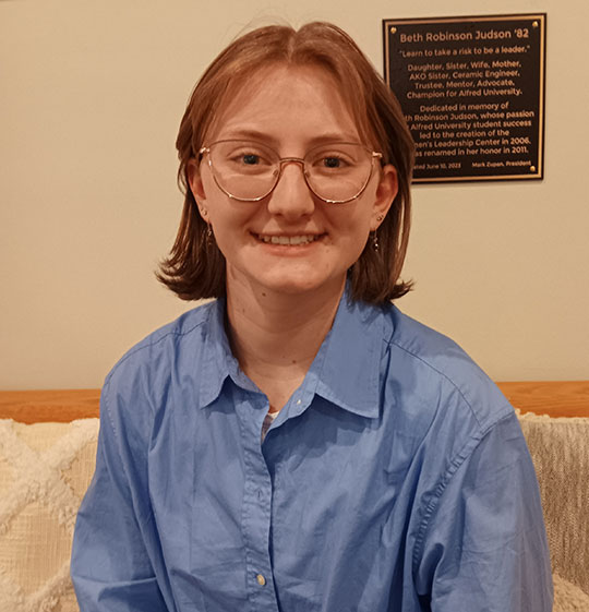 headshot of young woman with short hair and glasses