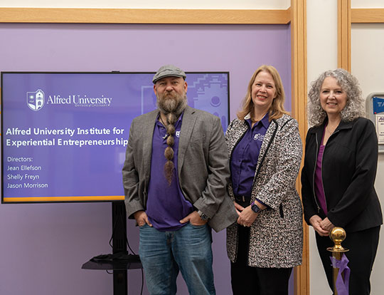 three people, a man and two women, standing in a row