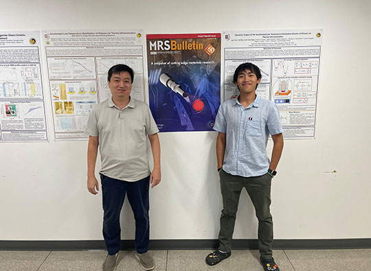 two men standing in a hallway in front of a poster