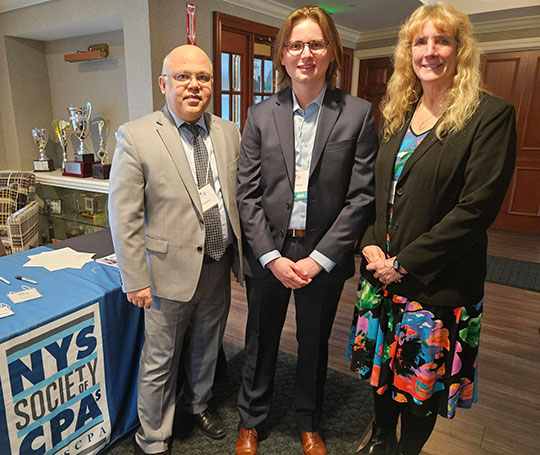 three people, two men and a woman, standing in a row