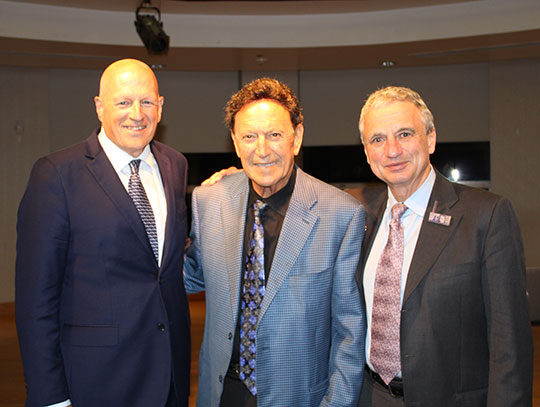three men standing in a row, smiling