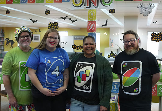 four people wearing Uno card game shirts